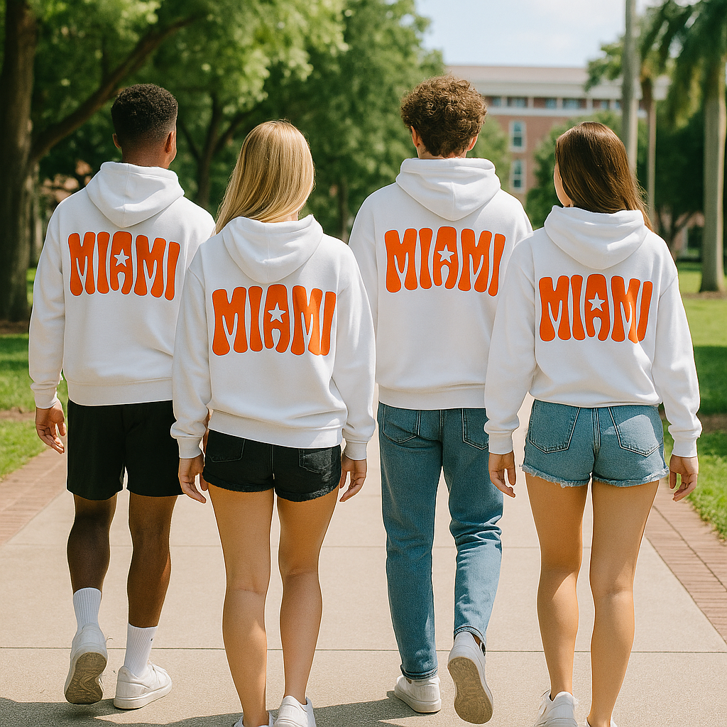 Four people wearing white hoodies with 'MIAMI' printed on the back, walking on a path outdoors.