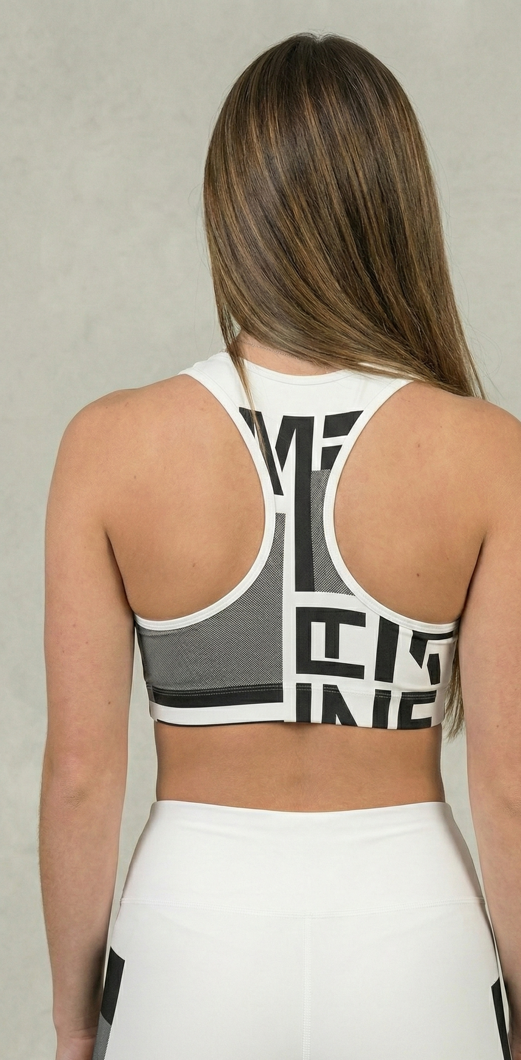 Person wearing a sports bra with branding on a plain background